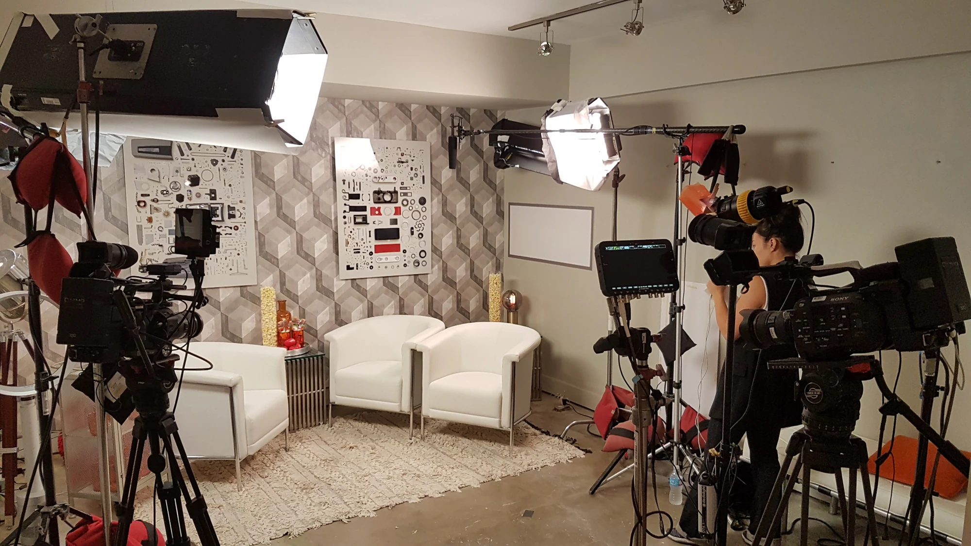 A two-camera interview setup with lights and chairs